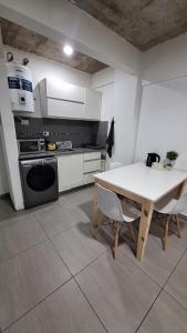 a kitchen with a white table and a table and chairs at Apartment Z Alberdi Home in Belén de Escobar