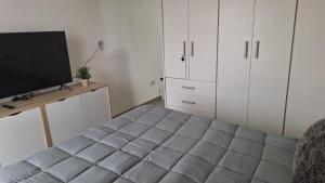 a bedroom with a bed and a flat screen tv at Apartment Z Alberdi Home in Belén de Escobar
