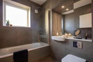 a bathroom with a tub and a toilet and a sink at Modern Townhouse Birmingham in Birmingham