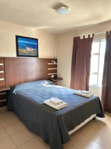 a bedroom with a bed with two towels on it at Marchetti Hotel Comedor in Miramar +28 photos