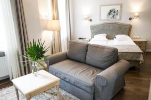 a living room with a couch and a bed at Guest House Senasis Pastas in Druskininkai