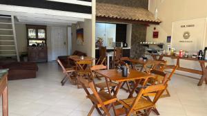 a dining room with wooden tables and chairs at Kundalini Buzios in Búzios