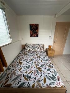 a bedroom with a bed with a floral bedspread at Kaz alizé in Sainte-Marie
