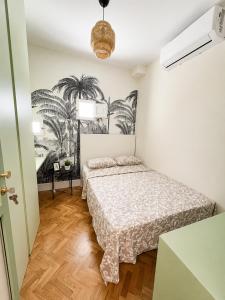 a bedroom with a bed and palm trees on the wall at Gato street, Private rooms in Madrid