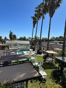 a resort with a pool and palm trees at Marchetti Hotel Comedor in Miramar