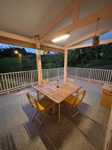 a wooden table and chairs on a porch at Kaz alizé in Sainte-Marie
