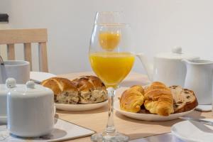 a table with two plates of pastries and a glass of orange juice at Park View-modern 2 bed apartment in Motherwell