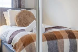 a bed with a blanket and a teddy bear on it at Park View-modern 2 bed apartment in Motherwell