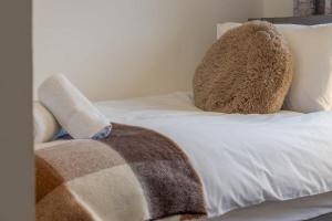 a white bed with a large stuffed animal on it at Park View-modern 2 bed apartment in Motherwell