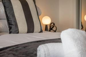 a bed with a black and white pillow and two lamps at Park View-modern 2 bed apartment in Motherwell +22 photos