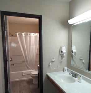 a bathroom with a sink and a toilet and a mirror at Super 8 by Wyndham Dunbar/Charleston Area in Charleston