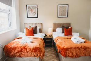 two beds sitting next to each other in a bedroom at The High Town Suite in Luton