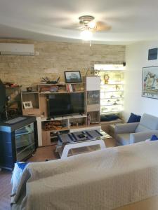 a living room with a couch and a tv at Apartment SPA Carpe Diem 1 in Utjeha