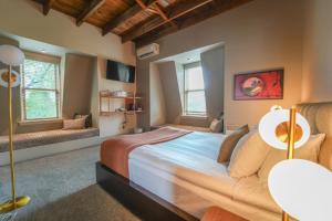 a bedroom with a large bed and two windows at Le Pleasant Hôtel in Sutton