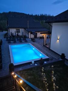 a swimming pool in the yard of a house at night at Mlynski in Mykulychyn