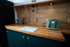 a counter with a green appliance on a wooden counter top at Castle Grant - 4 Bed Cottage in Gardenstown in Gardenstown