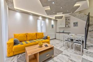 a living room with a yellow couch and a table at Brvnara Mont 1 in Zlatibor