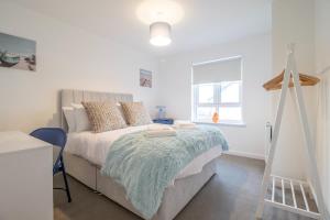 a bedroom with a bed with a blue blanket at Lendrick House-Spacious 3 Bed House in Falkirk in Polmont