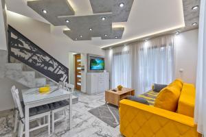 a living room with a yellow couch and a table at Brvnara Mont 1 in Zlatibor