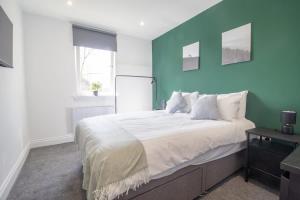 a bedroom with a large bed with a blue wall at Highfield Apartment- 2 Bed in Motherwell close to centre in Motherwell