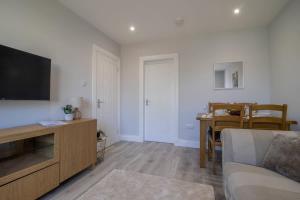 a living room with a couch and a flat screen tv at Highfield Apartment- 2 Bed in Motherwell close to centre in Motherwell