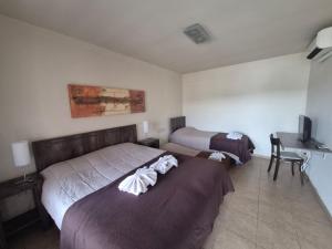 a hotel room with two beds and a desk at Hotel Urbana in Córdoba