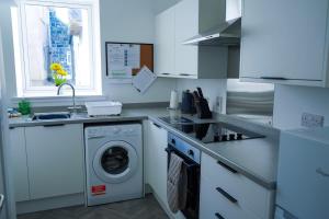 a kitchen with a washing machine and a sink at Park House - 3 bedroom in Portsoy