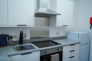 a kitchen with white cabinets and a stove top oven at Park House - 3 bedroom in Portsoy