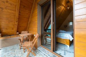 a room with a bed and a table and chairs at Brvnara Mont 1 in Zlatibor