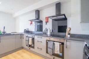 a large kitchen with stainless steel counters and appliances at Alexandra Apartment - Single Room #1 in Falkirk
