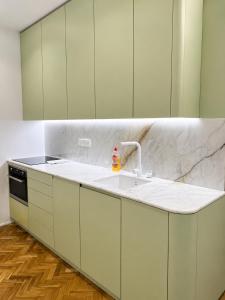 a kitchen with white cabinets and a sink at Gato street, Private rooms in Madrid