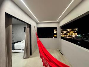 a red hammock in a room with a bedroom at Arcoverde - Varanda com Vista Panorâmica - excelente localização - até 6 pessoas in Arcoverde