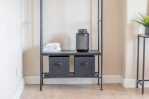 a black shelf with a vase on it in a room at Mitchell Apartment in Airdrie +20 photos
