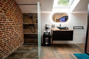 a bathroom with a sink and a brick wall at Domaine de Donstiennes in Thuin +33 photos