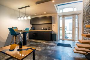 a kitchen with black cabinets and a table and chairs at Domaine de Donstiennes in Thuin