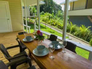 a wooden table with chairs and wine glasses on a porch at Spot on Drago in Bocas Town