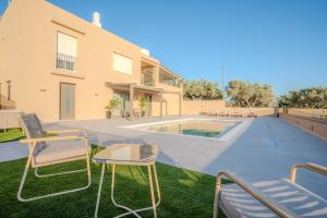 an image of a backyard with chairs and a swimming pool at Nautilus Villa - Private Pool II in Elaía