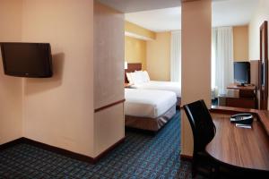 a hotel room with a bed and a desk and a tv at Fairfield by Marriott Frankfort in Frankfort