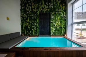 a swimming pool in a room with a green wall at Domaine de Donstiennes in Thuin