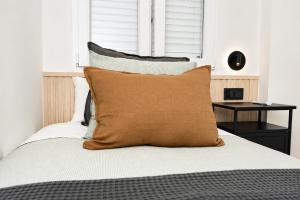 a bed with a brown pillow on top of it at Carvajal Street, Private rooms in Madrid