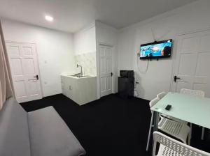 a room with a sink and a tv on the wall at Colony Stay in Paramaribo