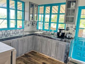 a kitchen with blue windows and a sink at El Rincón del Sol y Luna in Quimbaya