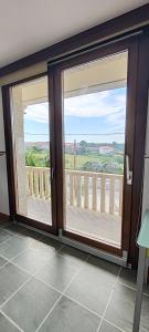 a room with two sliding glass doors with a balcony at Casa Vilanova Costa da Morte in Cee