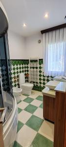 a bathroom with two toilets and a green and white checkered floor at Casa Vilanova Costa da Morte in Cee +25 photos