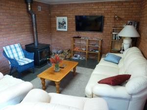 a living room with white couches and a wood stove at Panorama on Sorell B&B in Sorell