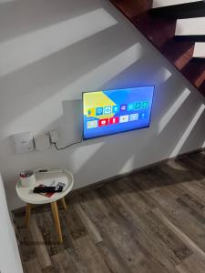 a tv on a wall in a living room at Punta Negra - Cabañas Cacarelhos in Piriápolis