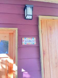 a sign on the side of a purple house at Punta Negra - Cabañas Cacarelhos in Piriápolis