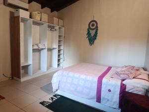 a bedroom with a bed and a shelf at The Mango House in Caaguazú