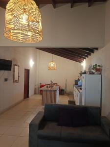 a living room with a couch and a kitchen at The Mango House in Caaguazú