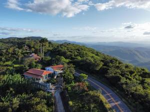 a house on a hill next to a road at Recanto nas Montanhas em Mulungu in Mulungu